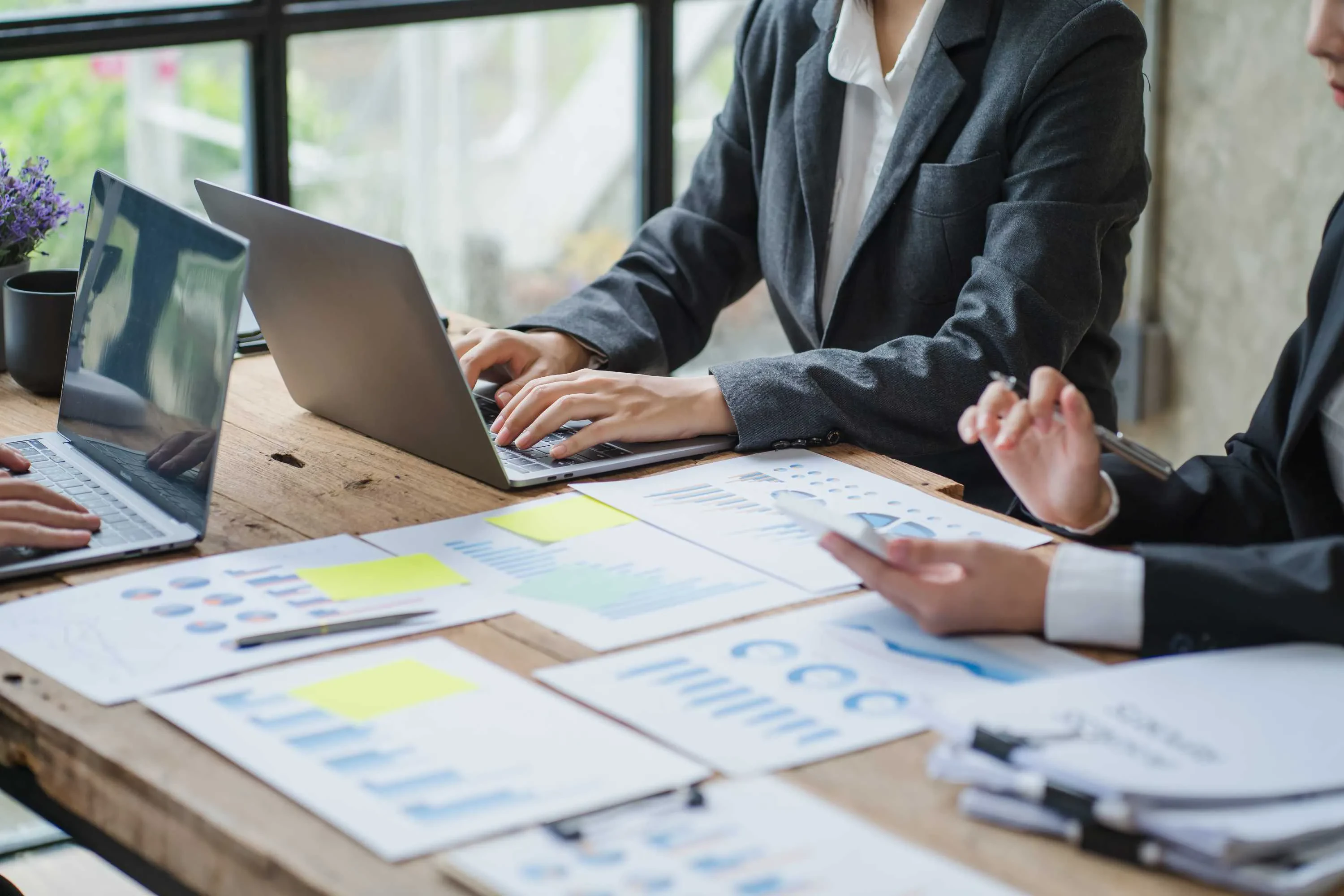 Zwei Personen im Business-Meeting mit Laptops und Diagrammen – Symbol für datengetriebene Teamarbeit und strategisches Projektmanagement