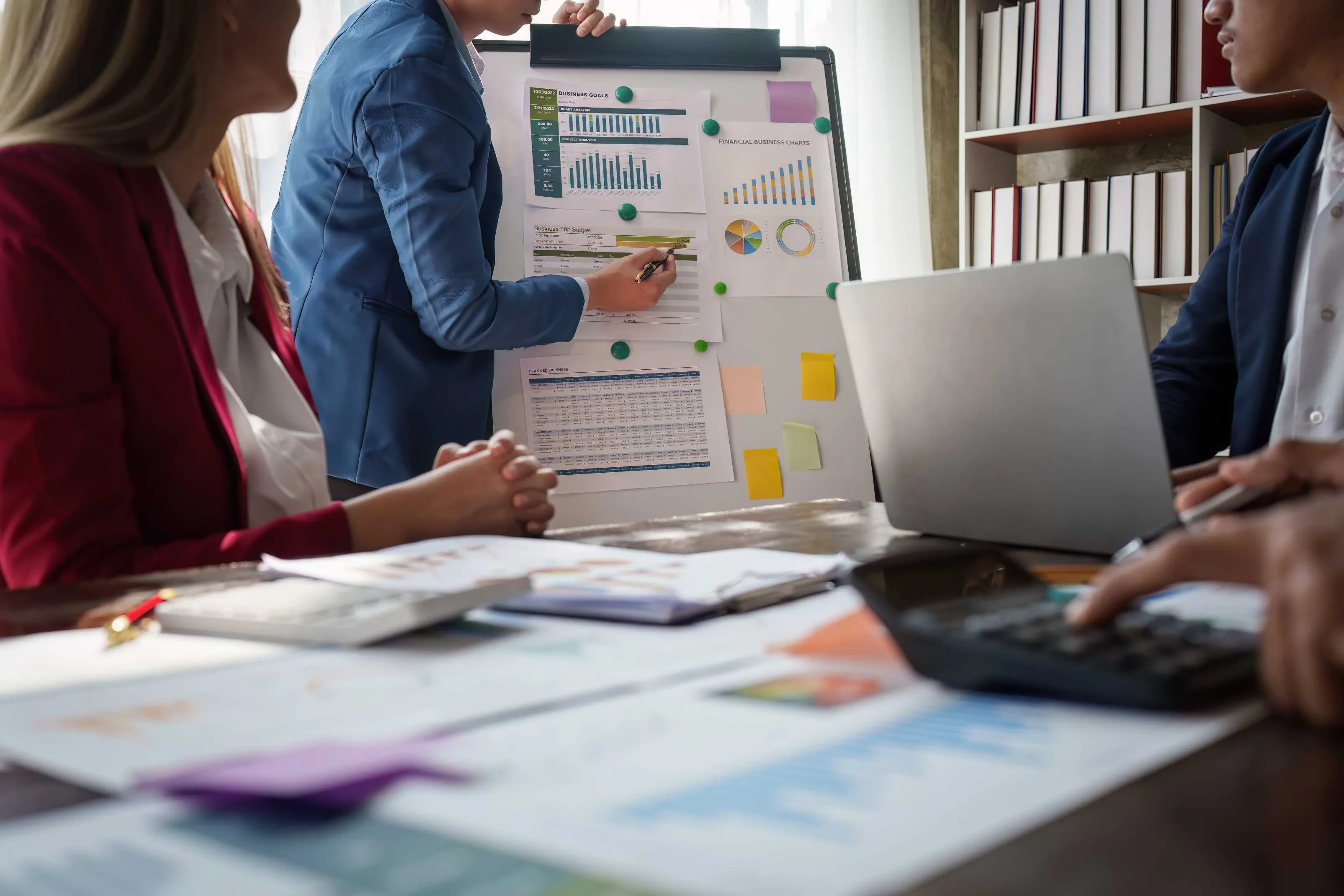 Person zeigt auf Flipchart mit Diagrammen im Business-Meeting – Symbol für datenbasierte Präsentation und strategische Projektplanung