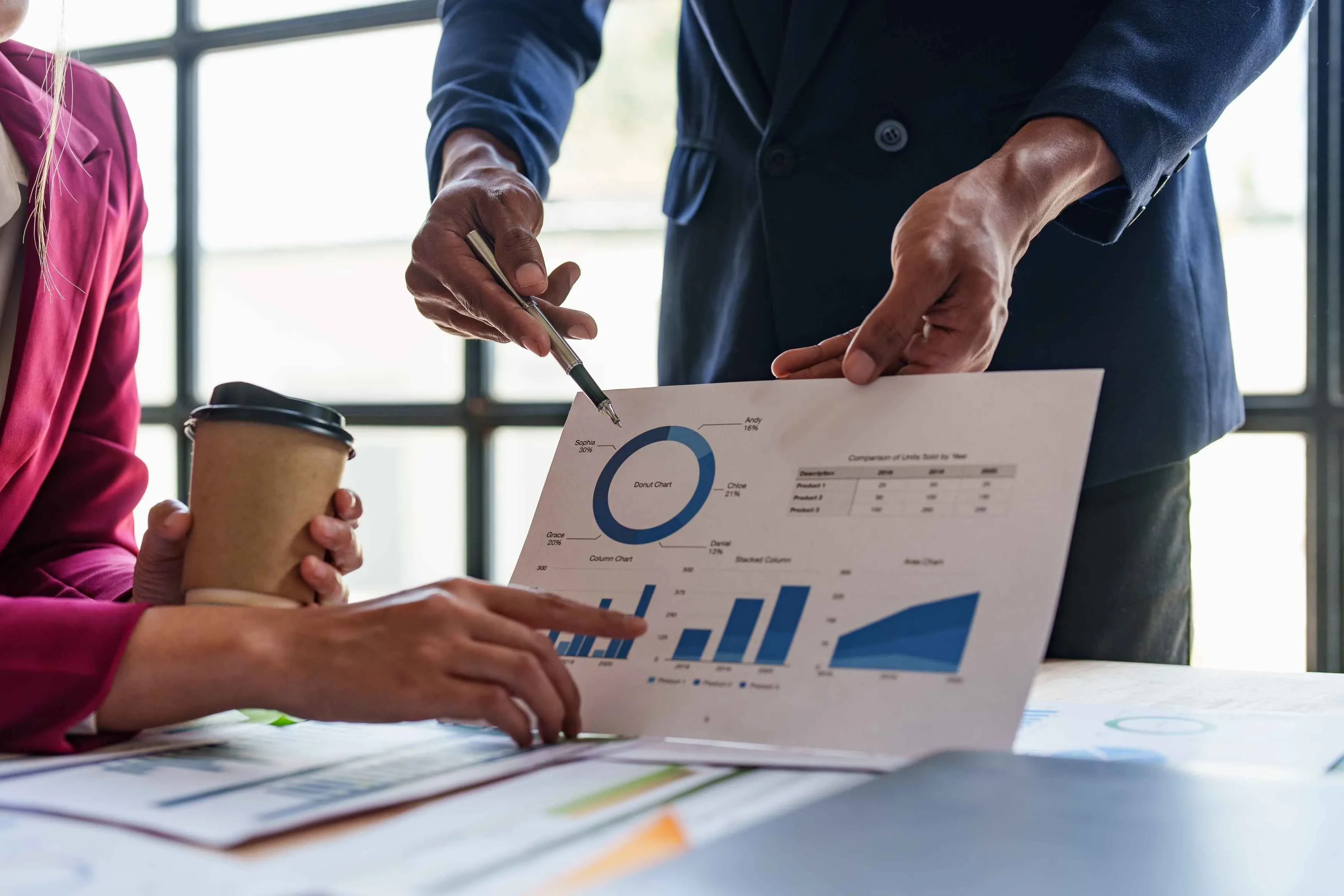 Zwei Personen im Gespräch über Diagramme und Daten – Symbol für kollaborative Projektanalyse und strategische Planung