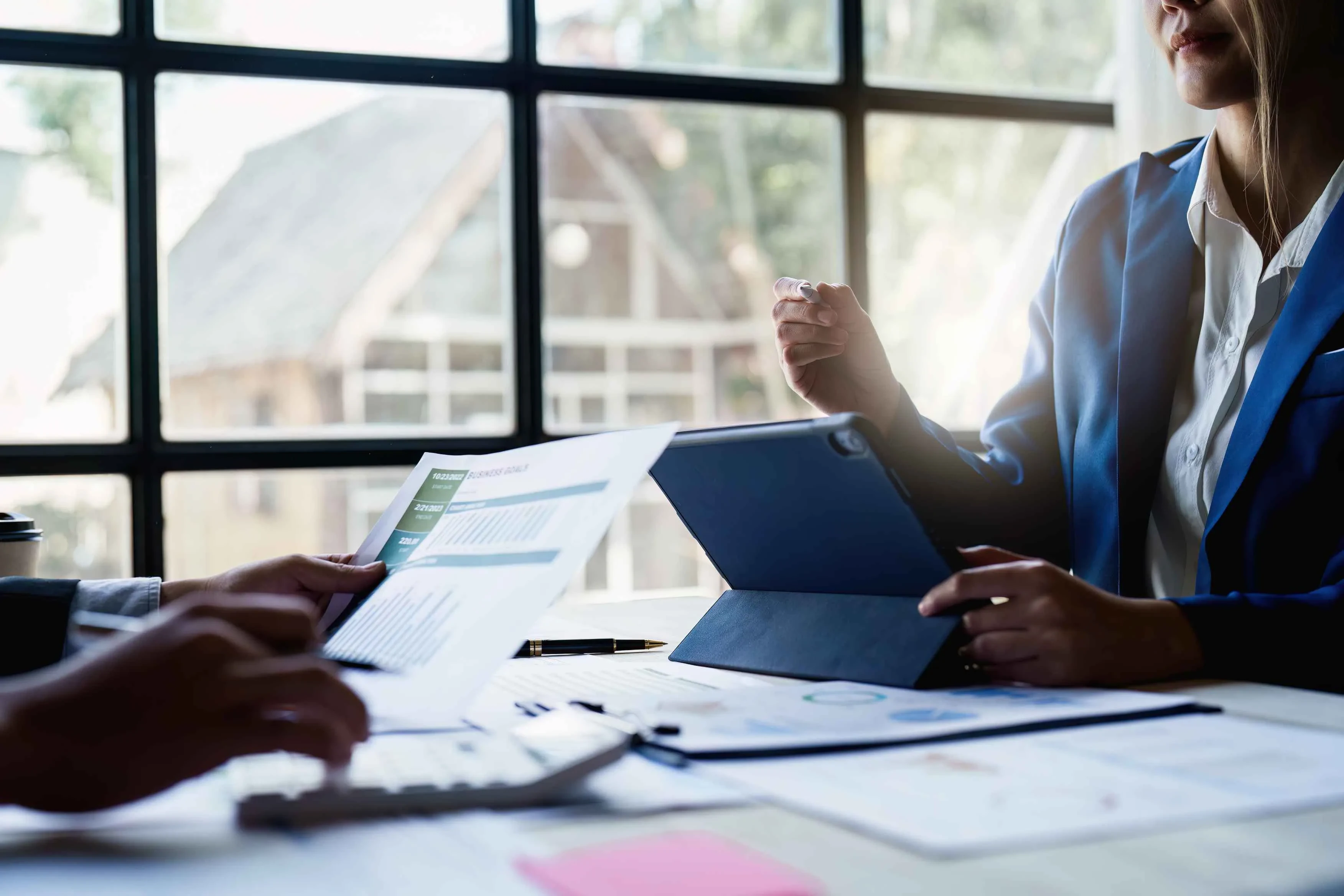 Zwei Personen mit Tablet und Charts im Gespräch – Symbol für datenbasierte Zusammenarbeit und digitale Projektplanung
